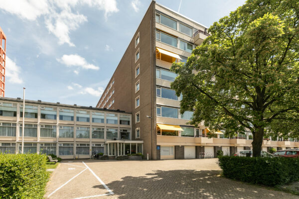 Modern apartment building with tree and blue sky