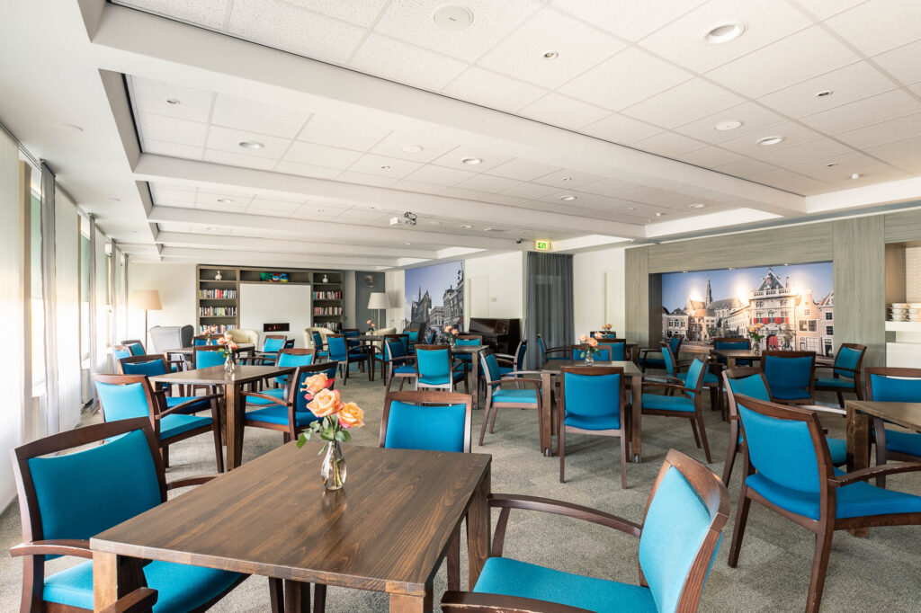 Bright meeting room with blue chairs and tables.