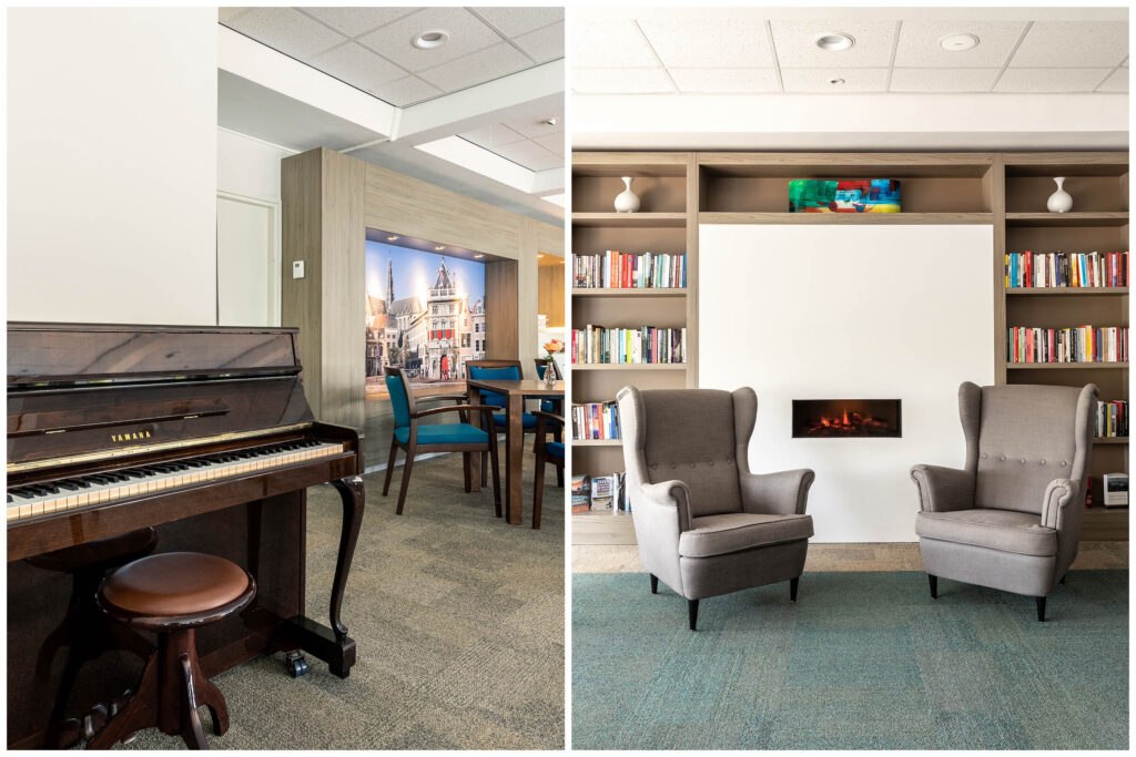 Cozy library with chairs, piano, books, and fireplace.