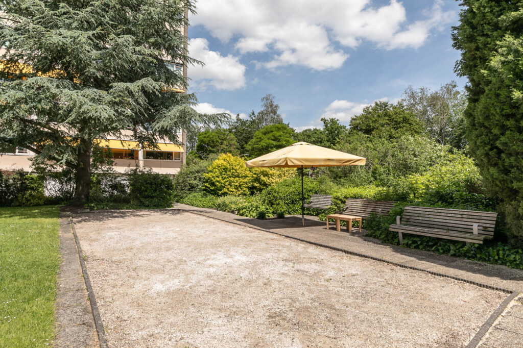 Garden area with benches and umbrella shade.