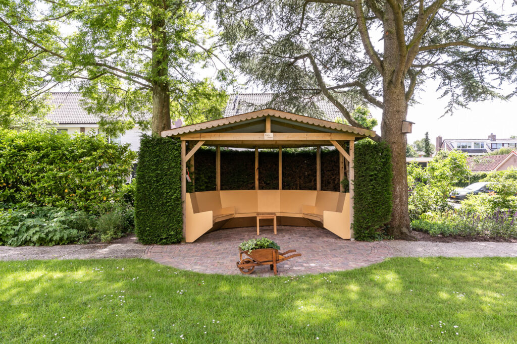 Garden gazebo with wooden bench and wheelbarrow