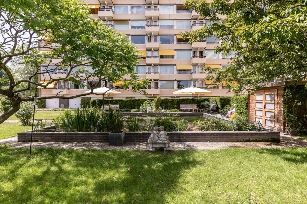 Apartment building with garden and seating area.