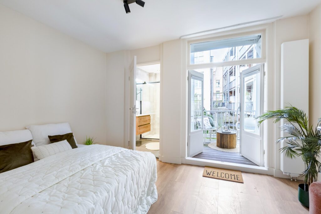 Cozy bedroom with balcony and bathroom view.