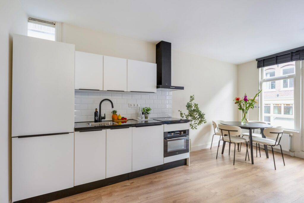 Modern kitchen with dining table and flowers.