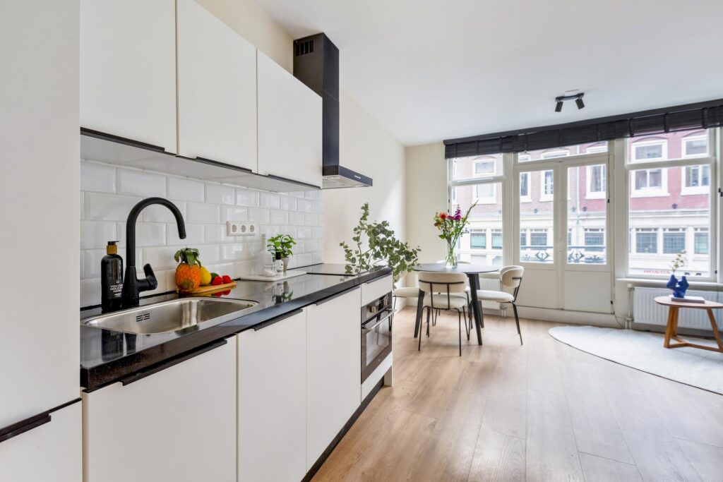Modern kitchen with dining area and large windows.