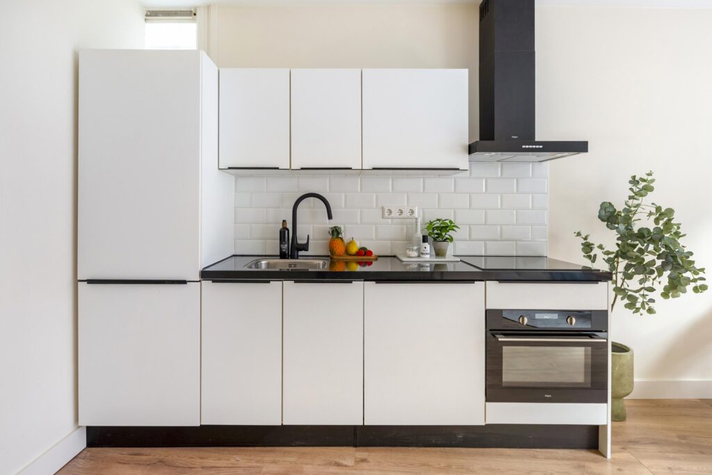 Modern kitchen with white cabinets and black appliances
