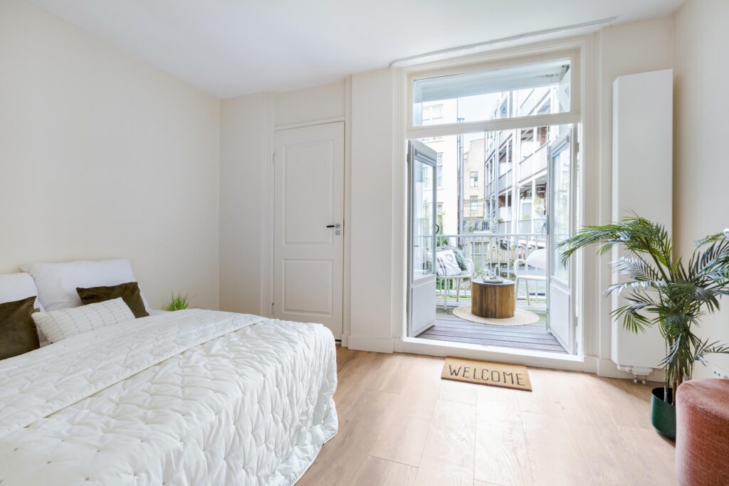 Cozy bedroom with balcony and welcome mat.