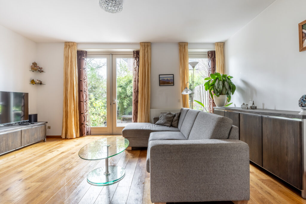 Cozy living room with sofa and large windows.