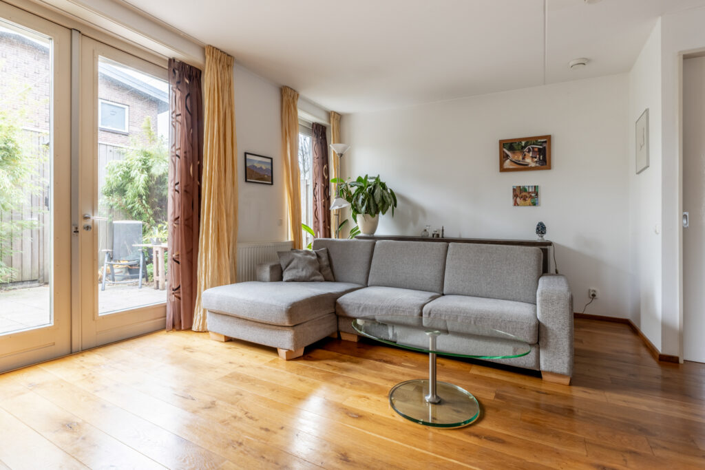 Modern living room with gray sofa and glass table.