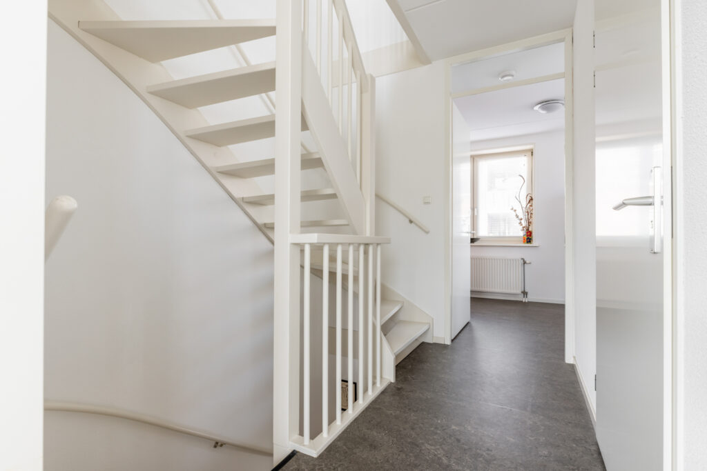 Minimalist white staircase in modern interior hallway.