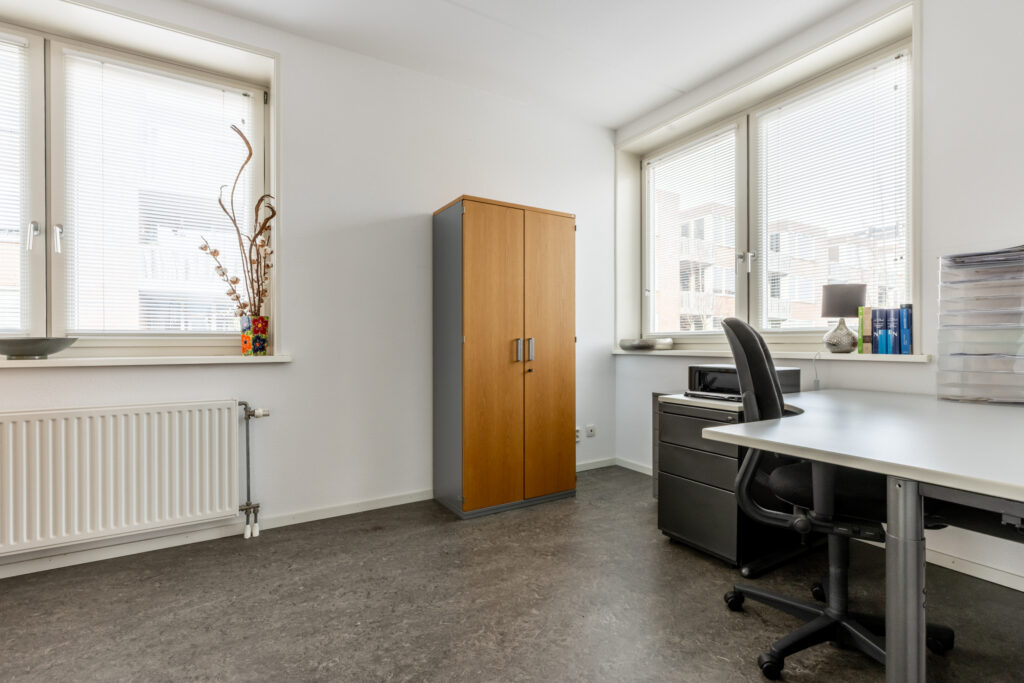 Modern office with desk, chair, and cabinet.