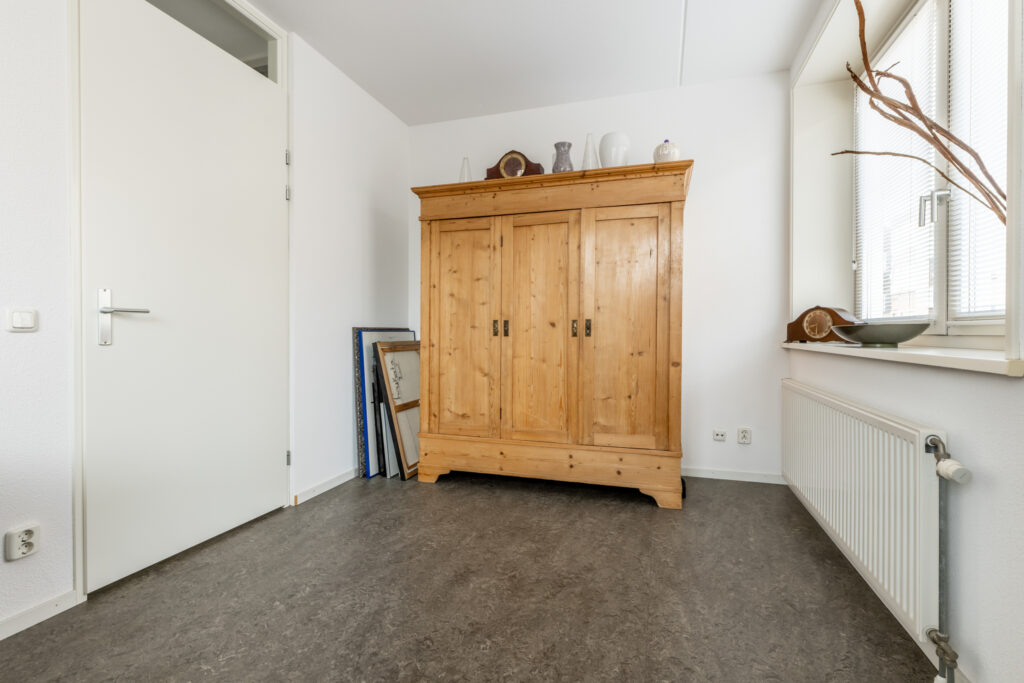 Minimalist room with wooden wardrobe and large window.
