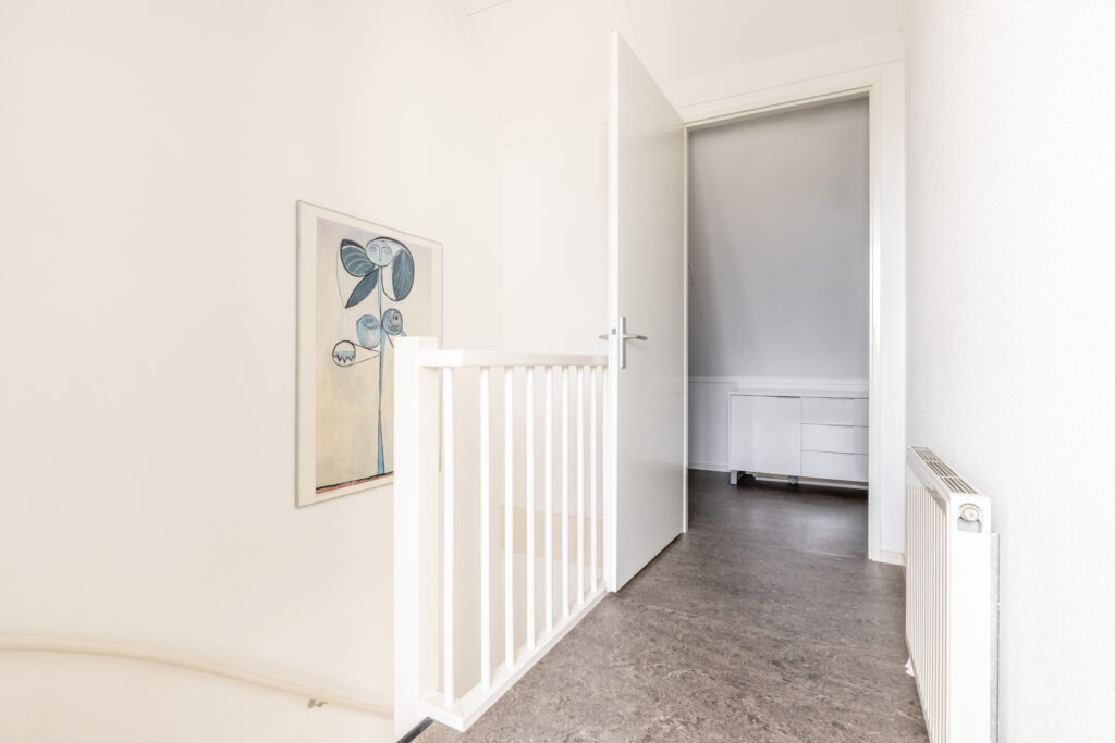 Minimalist hallway with painting and open door