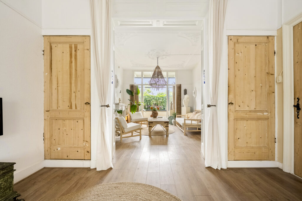 Bright living room with wooden furniture and chandelier.
