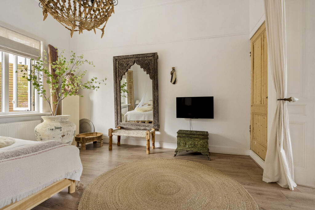 Rustic bedroom with large mirror and decor.