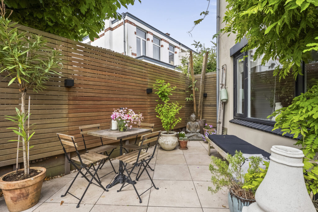 Cozy patio with plants and outdoor seating.