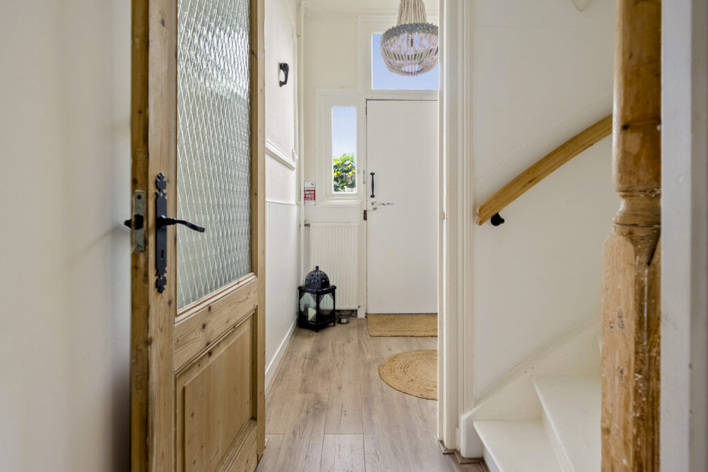 Cozy hallway with wooden door and stairs.
