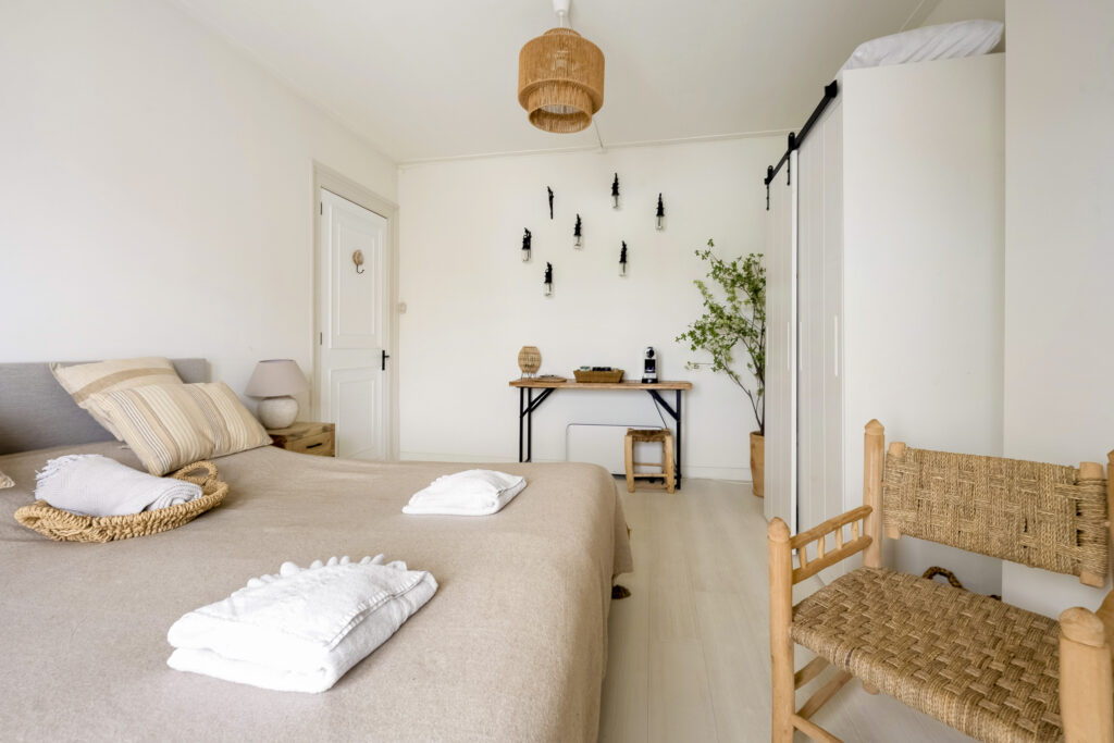 Cozy bedroom with beige decor and wooden furniture.