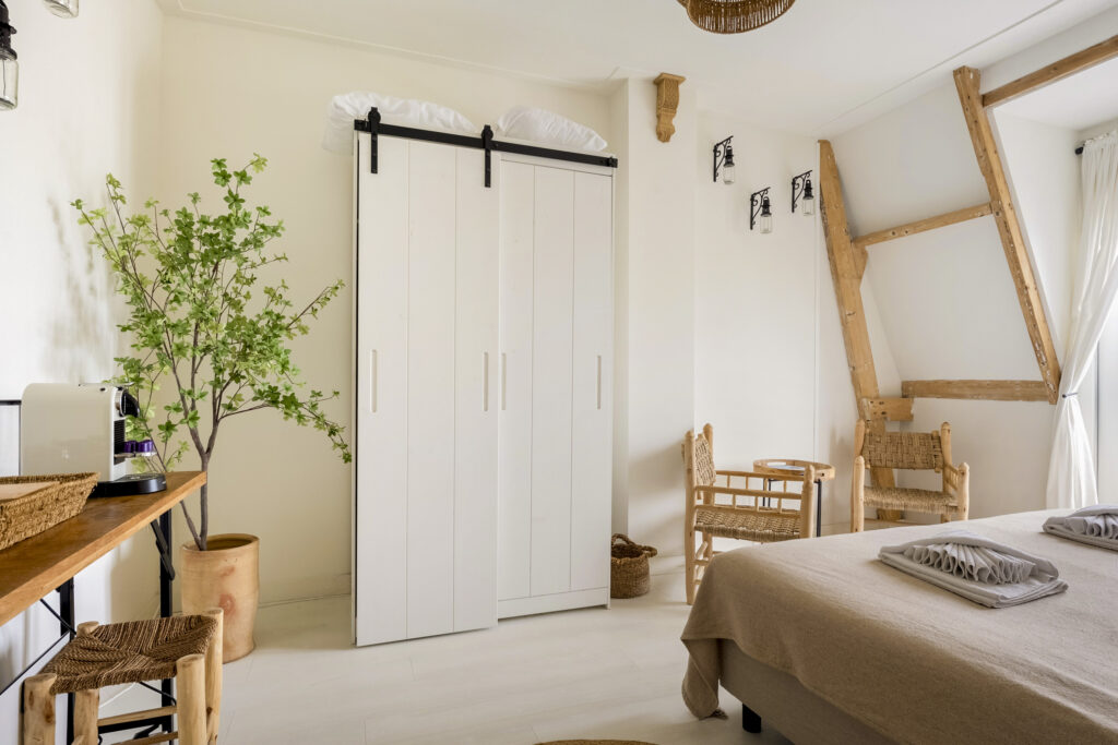 Cozy bedroom with natural decor and large wardrobe.