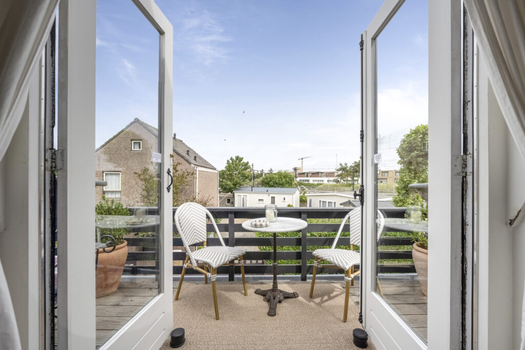 Cozy balcony with chairs and table, scenic view.