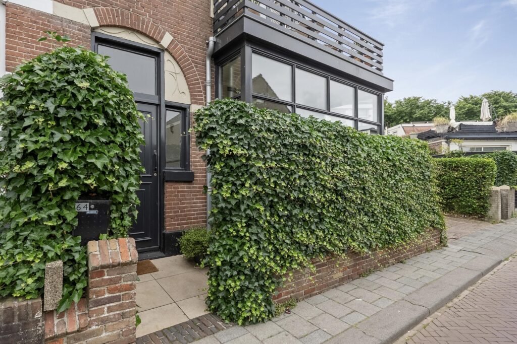 Brick house with ivy and modern windows.