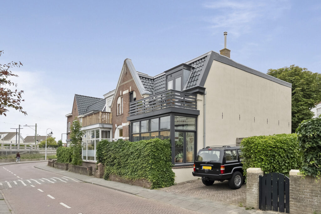 Modern house on a street corner with greenery.