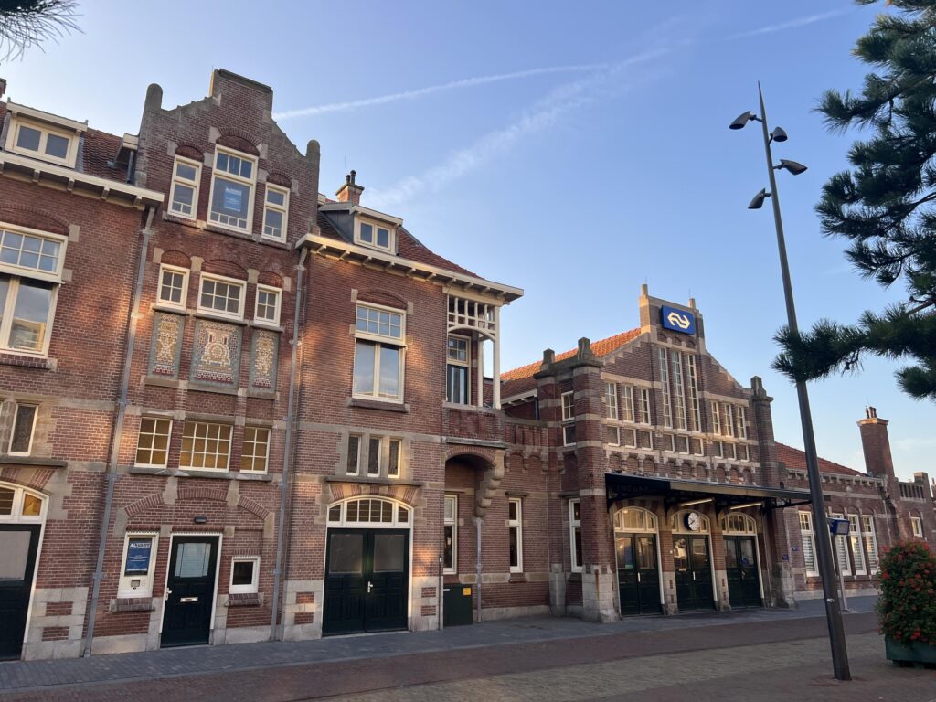 Historic brick train station facade with blue sky.