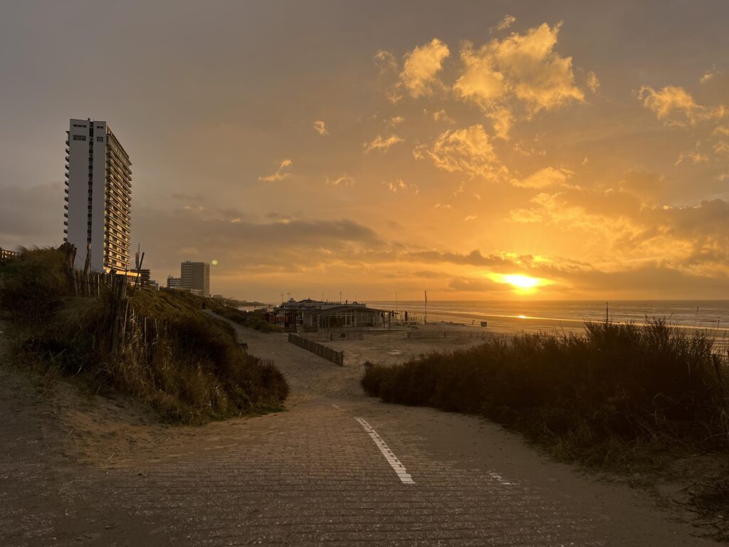 Golden sunset over sandy beach and buildings