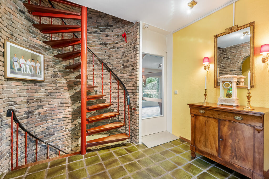 Red spiral staircase in vintage decorated room.