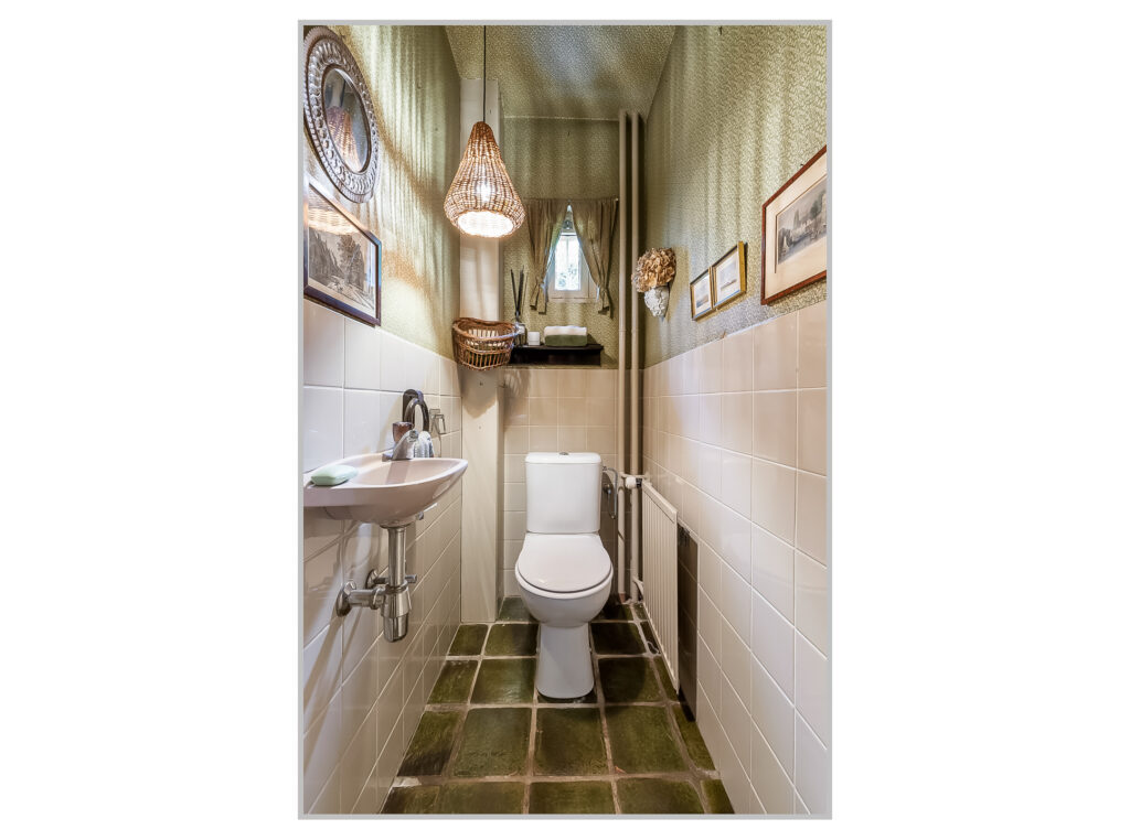 Cozy bathroom with toilet and decorative wall art.