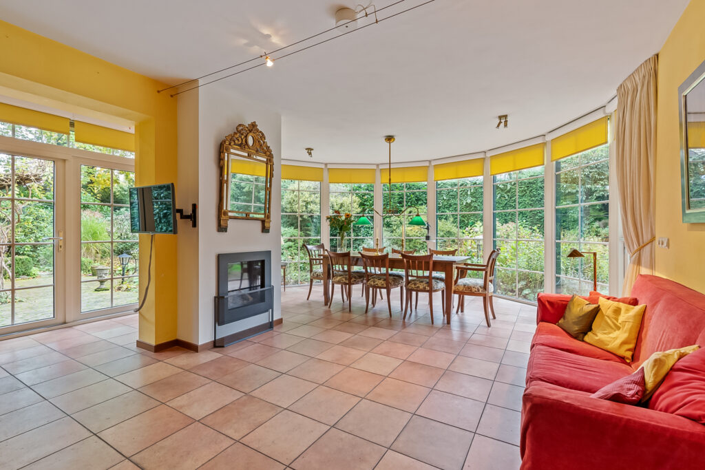Bright living room with large windows and fireplace.