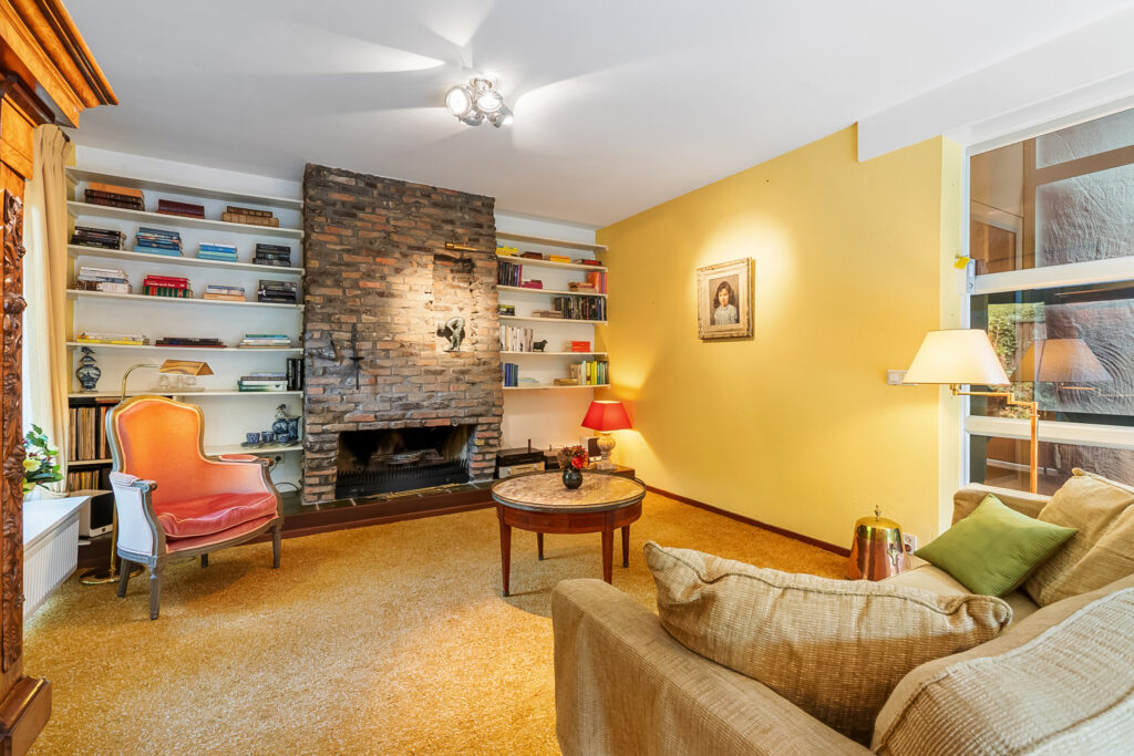 Cozy living room with brick fireplace and bookshelf.