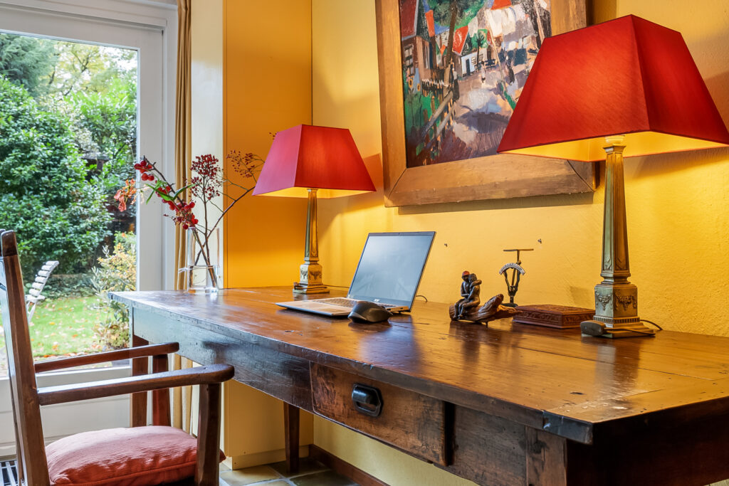 Cozy home office with desk and lamps.