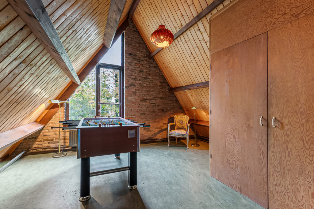 Attic game room with foosball table and chair.