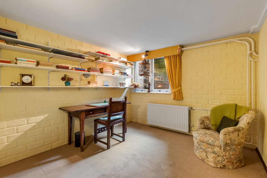 Cozy home office with desk and armchair.