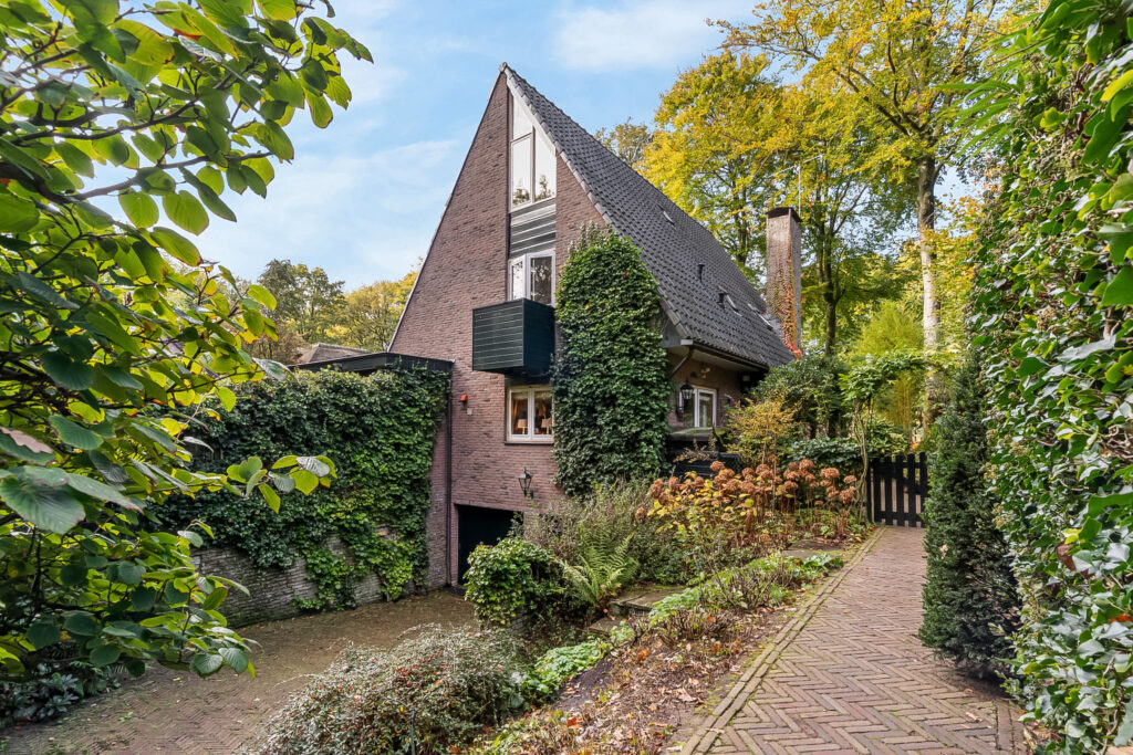 Charming brick house surrounded by lush greenery.