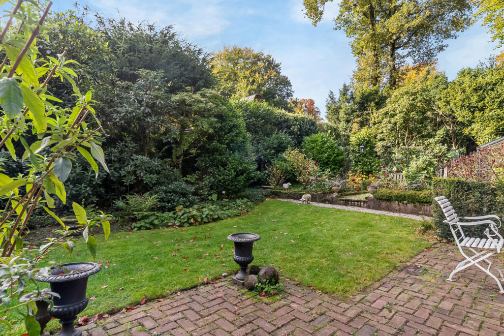 Lush garden with patio and white chair
