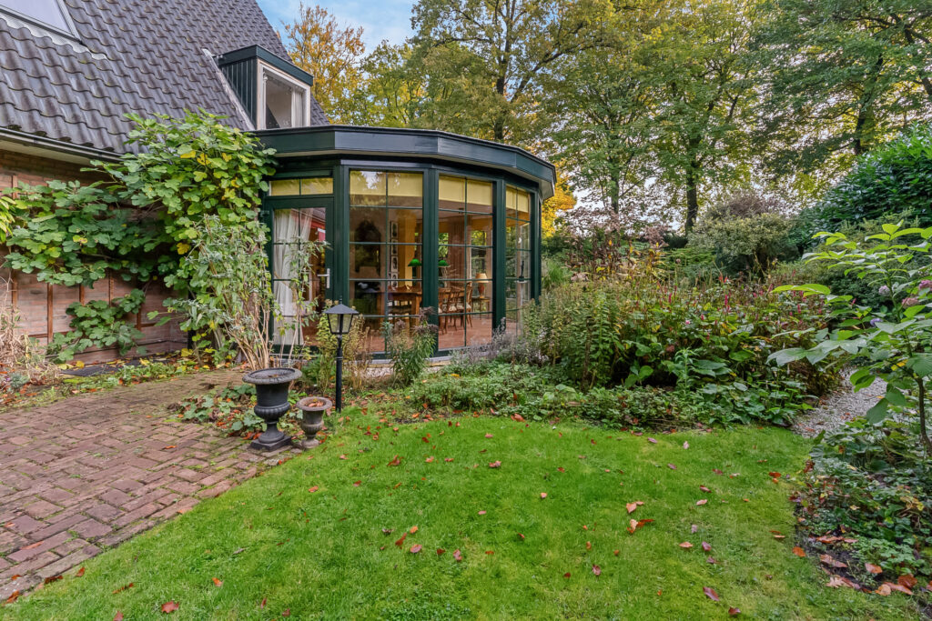 Cozy garden with glass sunroom and greenery