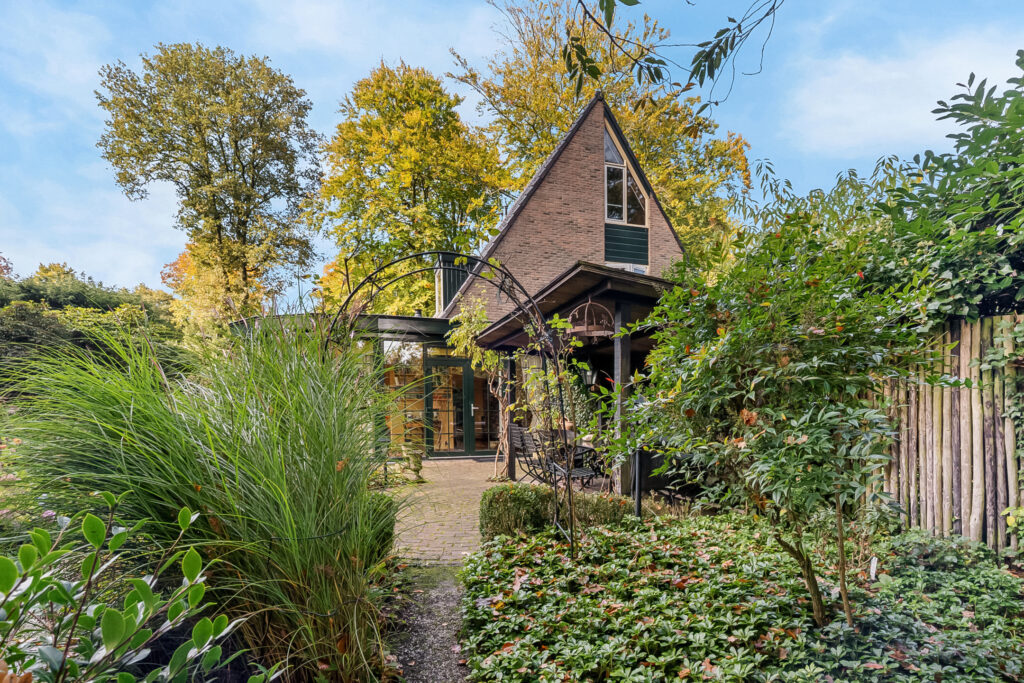 A-frame cabin surrounded by lush green foliage.