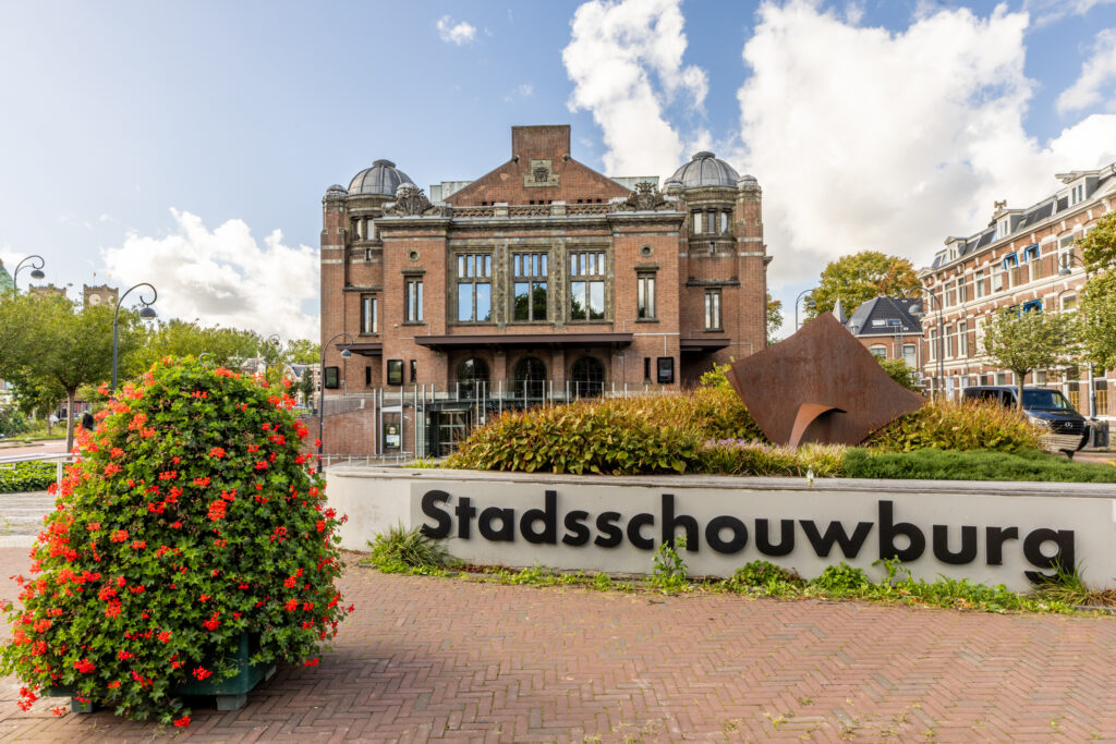 Stadsschouwburg building with garden and sculpture