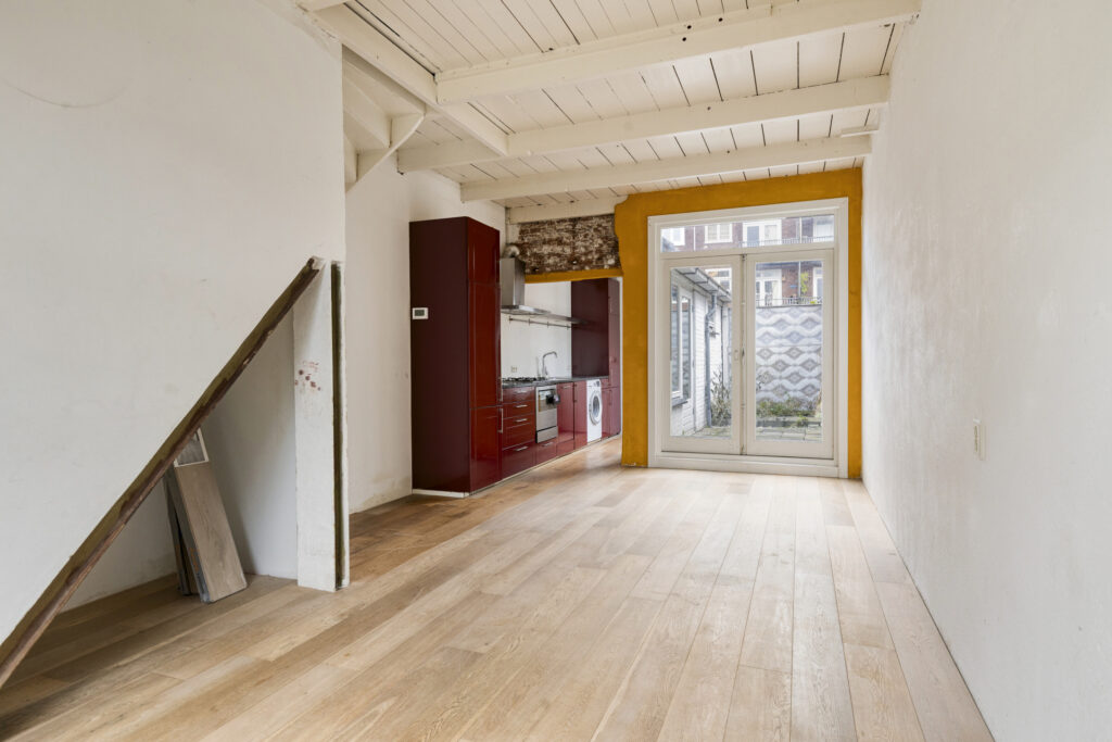 Spacious room with kitchen and glass doors.