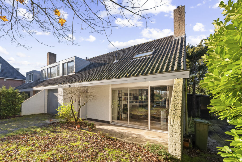 Modern suburban house with large windows and garden.