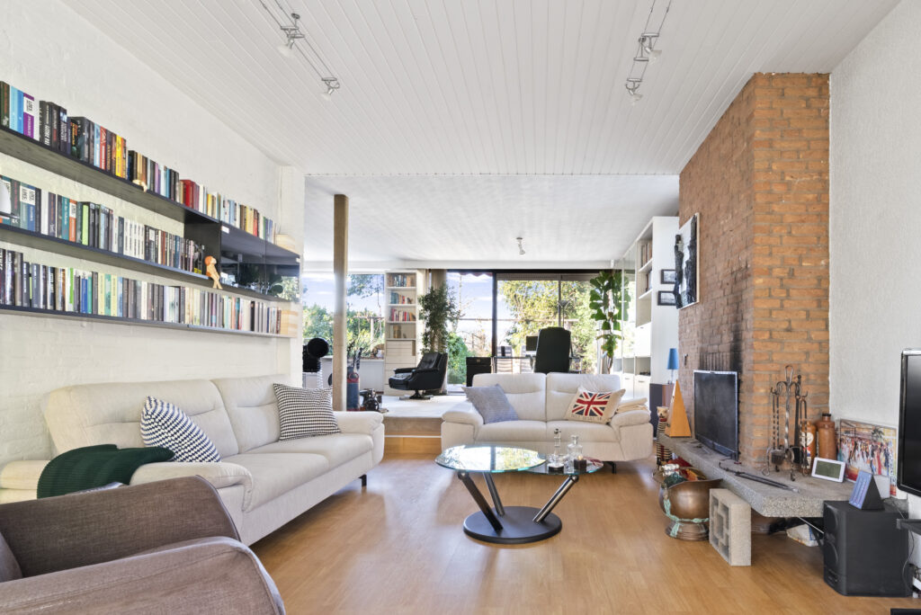 Modern living room with bookshelves and large windows.