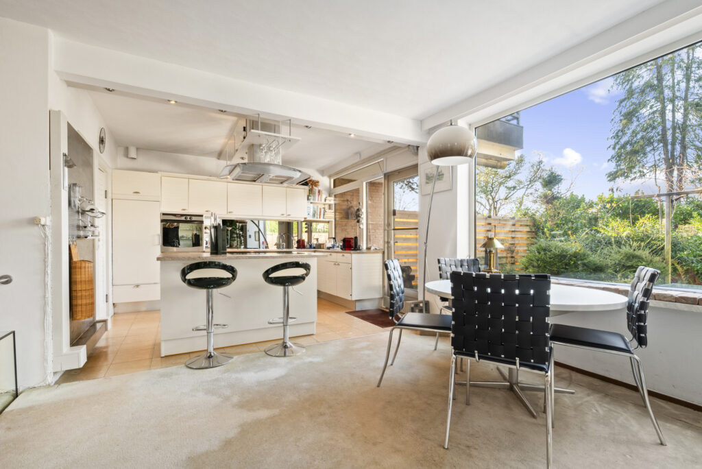 Modern kitchen and dining area with large windows.
