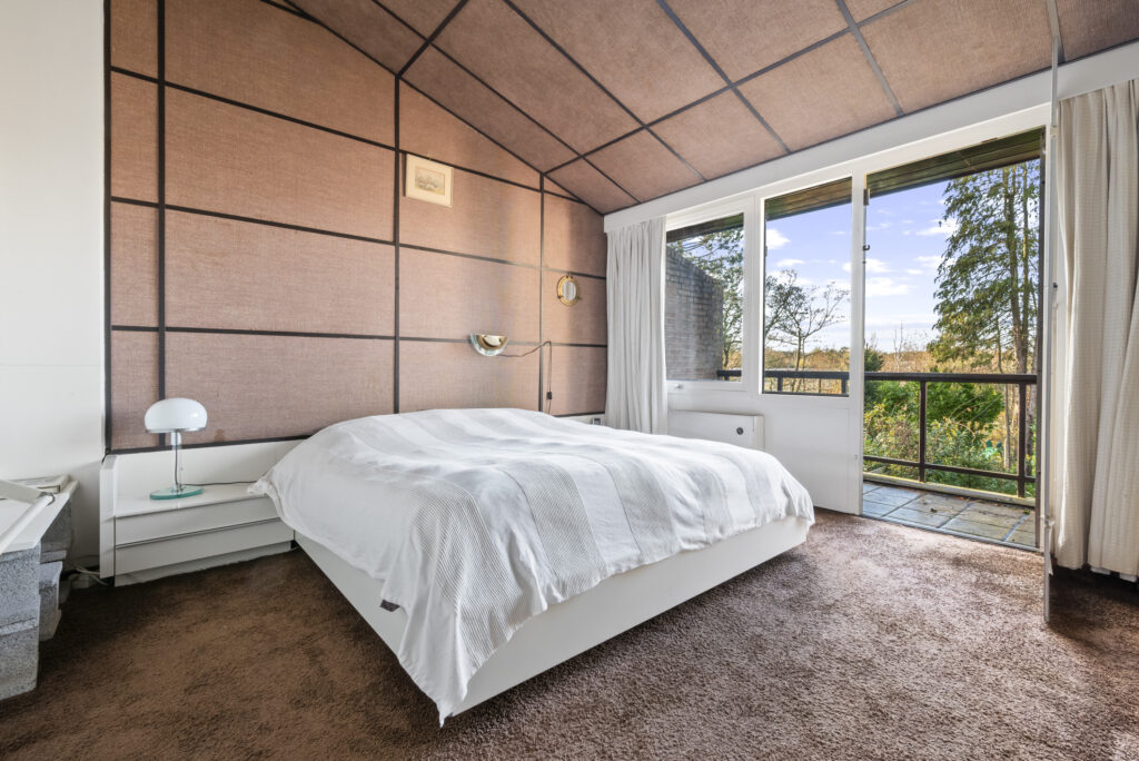 Cozy bedroom with large window and garden view.