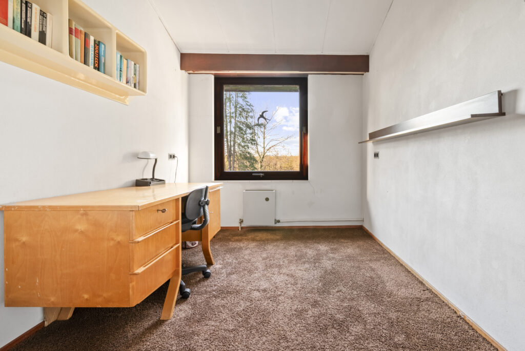 Minimalist study room with desk, chair, and window view.
