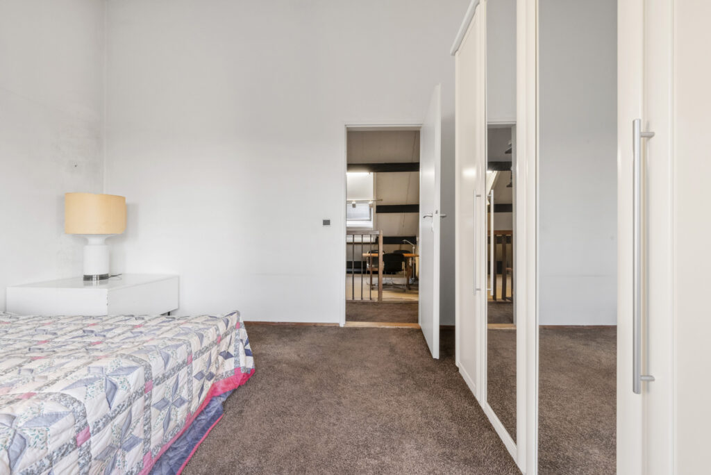 Minimalist bedroom with bed, lamp, and wardrobe