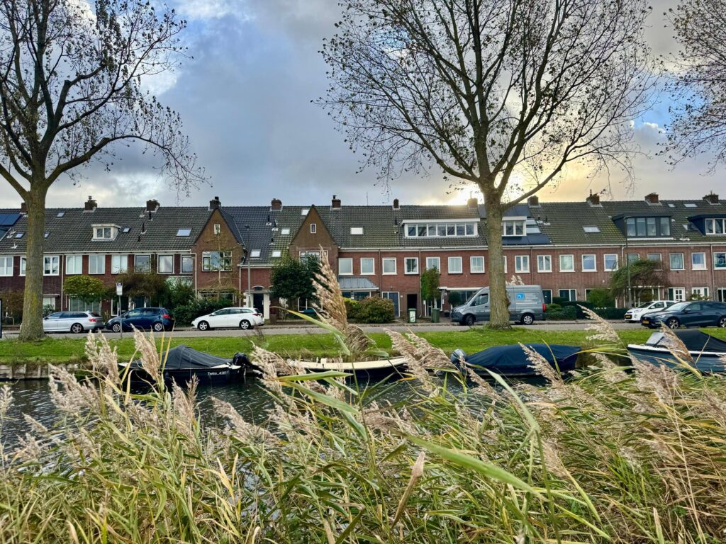 Row of houses by a canal with boats.
