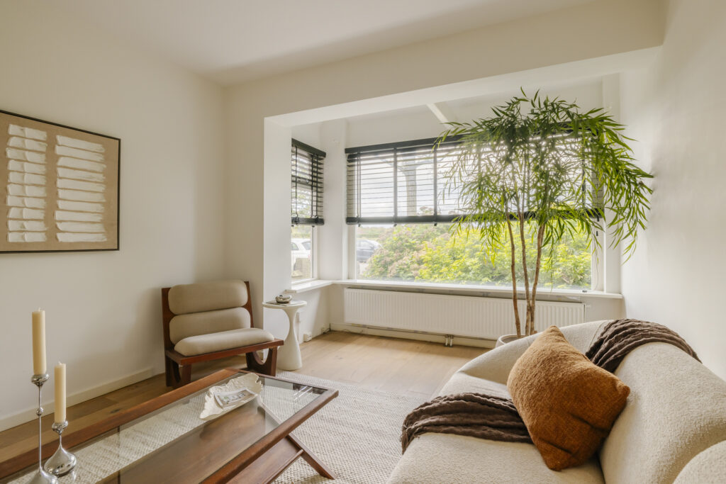 Bright living room with large window, cozy decor.