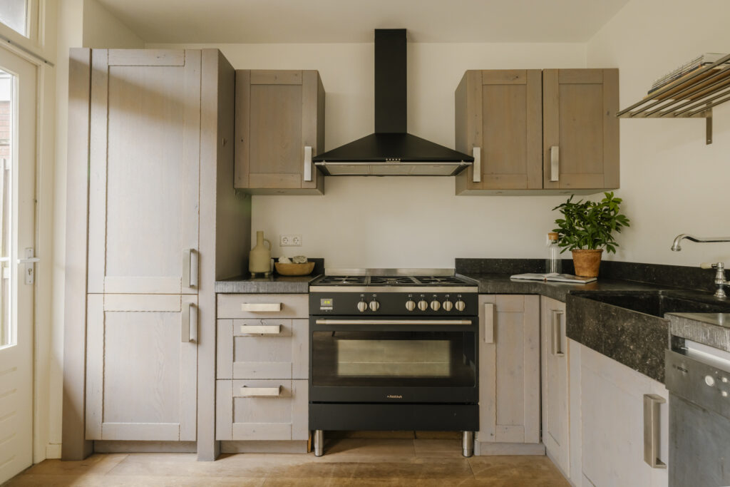Modern kitchen with wooden cabinets and black stove.